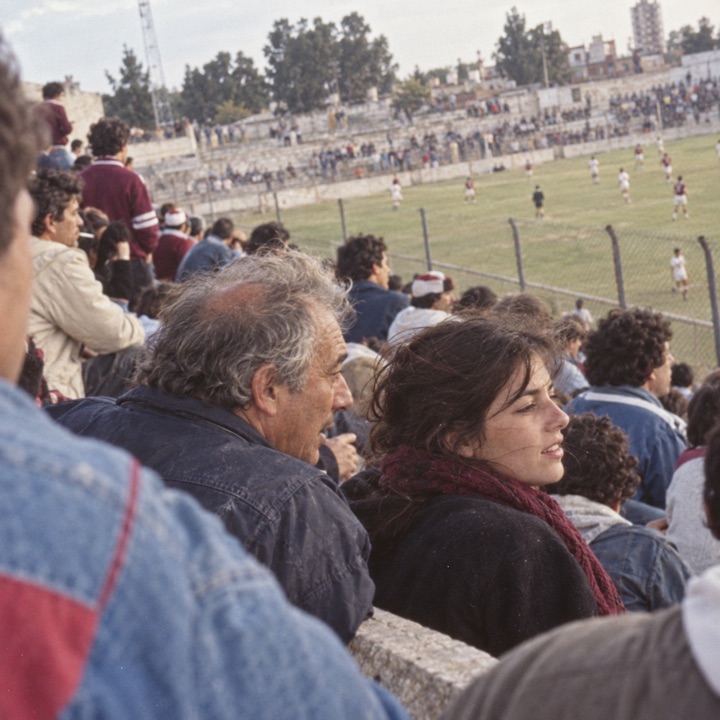 Illustrative family moment, an older man and a young woman talking in a local football stand